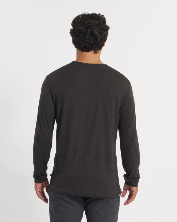 Back view of Men’s Aire long-sleeve alpaca shirt in black on model, showing relaxed fit against white background