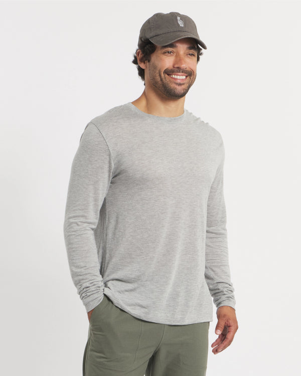 Front three-quarter view of Men’s Aire long sleeve shirt in heather grey on a model, lightweight alpaca blend crew neck showing relaxed fit on white background