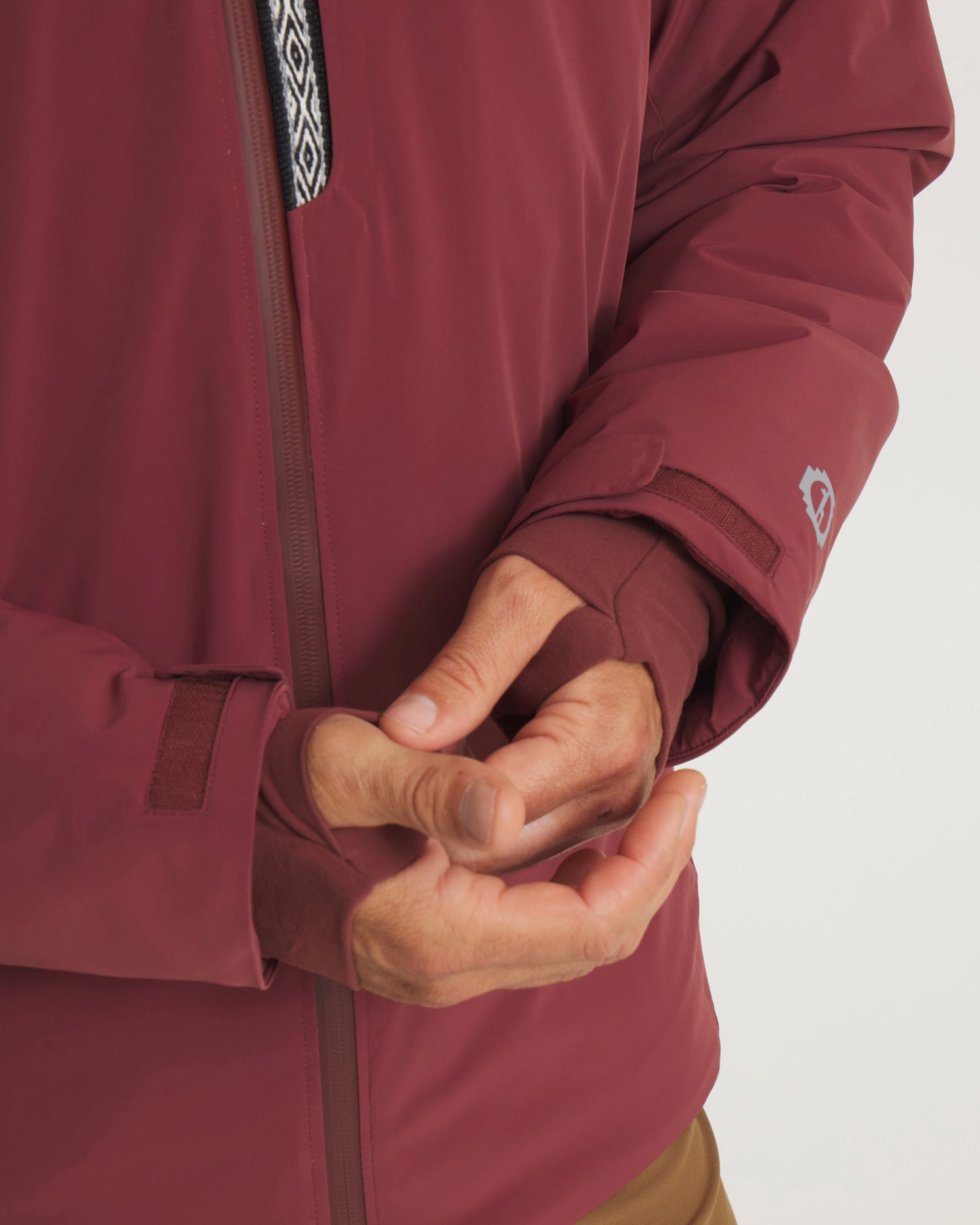 Close-Up of Hands Through Thumbholes of Burgundy Men’s Apu Parka Sustainable Ski Jacket – PAKA Apparel