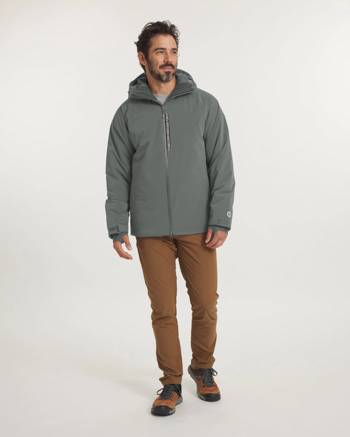 Full-body view of Men’s Apu Parka in eucalyptus showcasing a hooded insulated jacket with chest zip pocket on a model against a plain light background