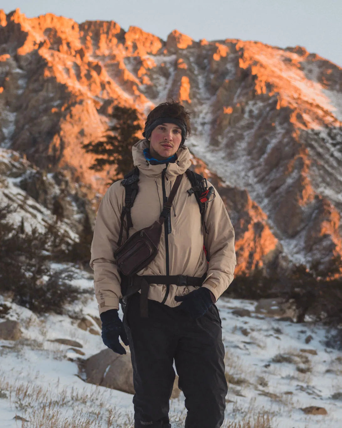 Man in Puma / Tan Apu Parka Winter Jacket in Snow with Jagged Mountain in Background – PAKA Apparel
