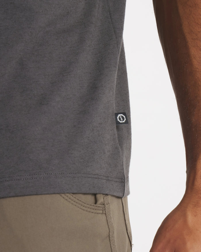 Side hem of charcoal Men’s Essential Tee showcasing PAKA side tag and straight hem against white background