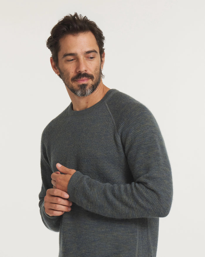 Three-quarter view of Men’s Mountain Crew sweater showing raglan sleeves and textured forest blue green knit