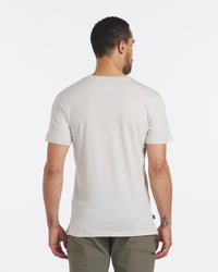 Back view of Men’s Pocket Tee in bone showing regular fit, short sleeves, crew neck, and straight hem on model against white background