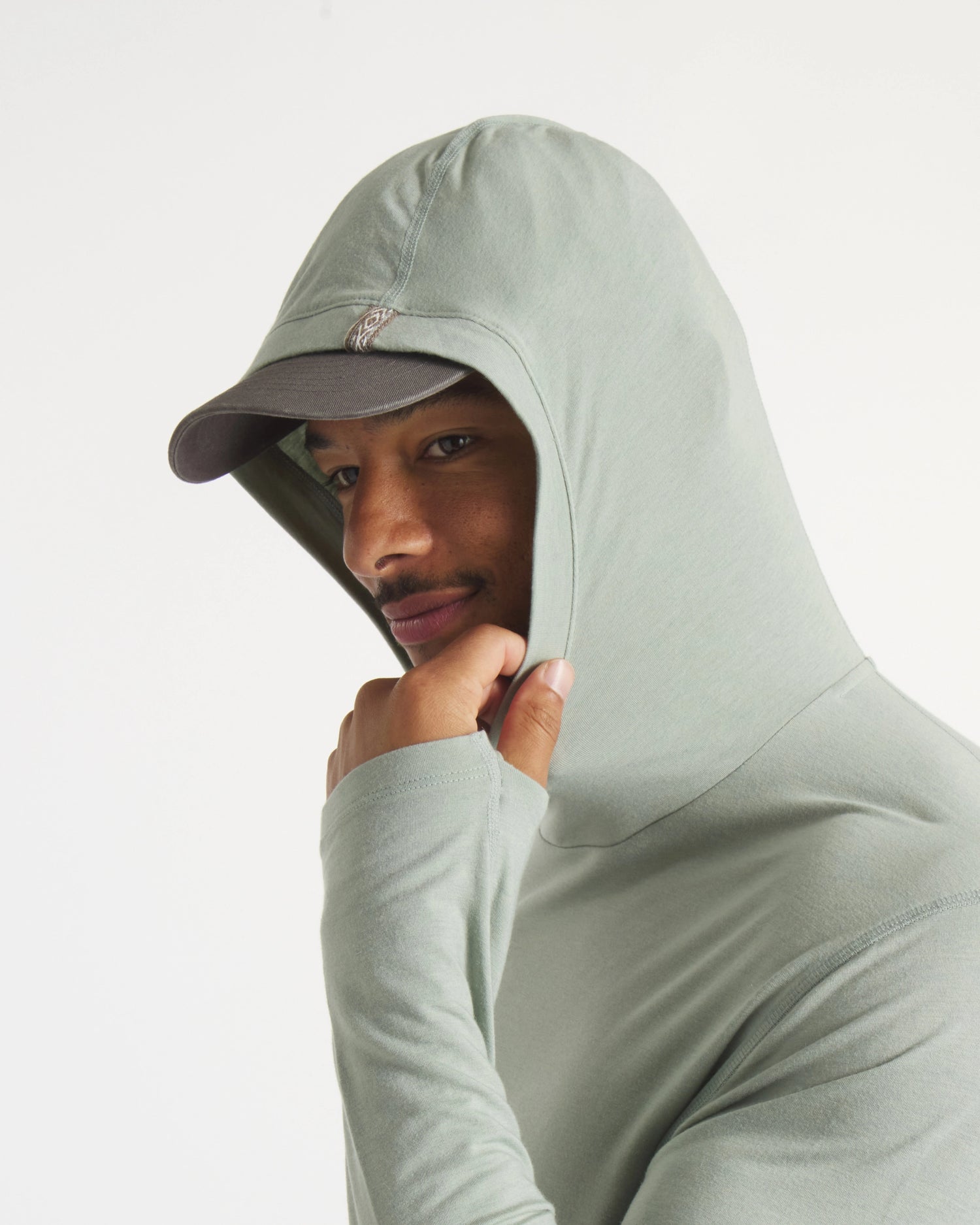 Close-Up of Hood Up on Model Wearing Sol Men's Alpaca Sun Protection Hoodie in Lichen / Light Green – PAKA Apparel