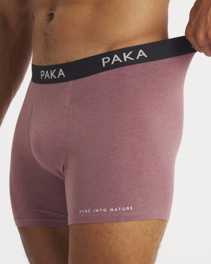 Side view of mauve Men’s Essential Boxer Brief on model showing black PAKA waistband and Sync Into Nature text on thigh