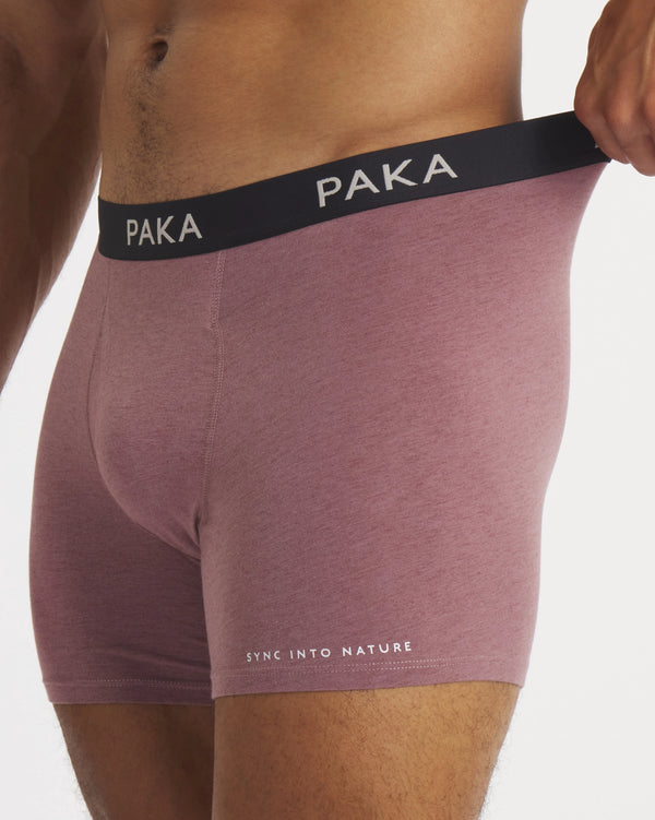 Side view of mauve Men’s Essential Boxer Brief on model showing black PAKA waistband and Sync Into Nature text on thigh