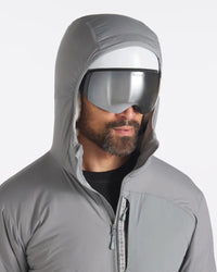 Front close-up of Men’s Apu Lightweight Puffer in Storm gray on model showing hood, full zip and chest pocket