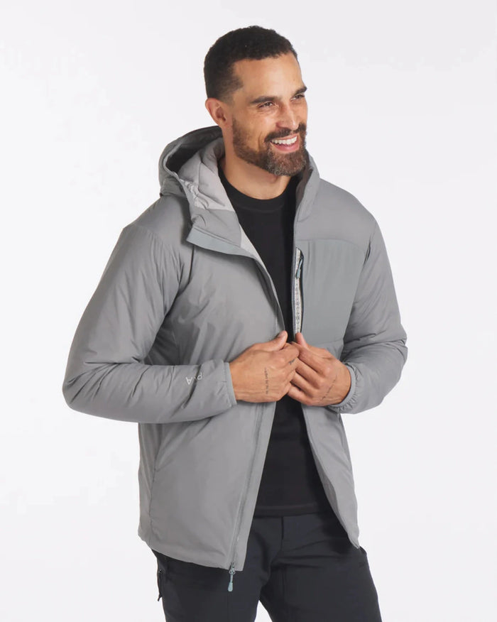 Three-quarter view of Men’s Apu Lightweight Puffer jacket in Storm gray with hood and chest zip pocket on model