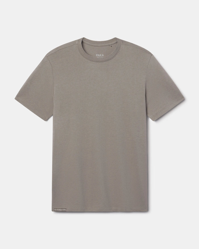 Front flat lay of Men’s Essential Tee in stone showing crew neck, short sleeves, and subtle branded hem tag on white background