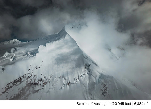 Snow-covered mountain summit rising through clouds in the Andes near Ausangate