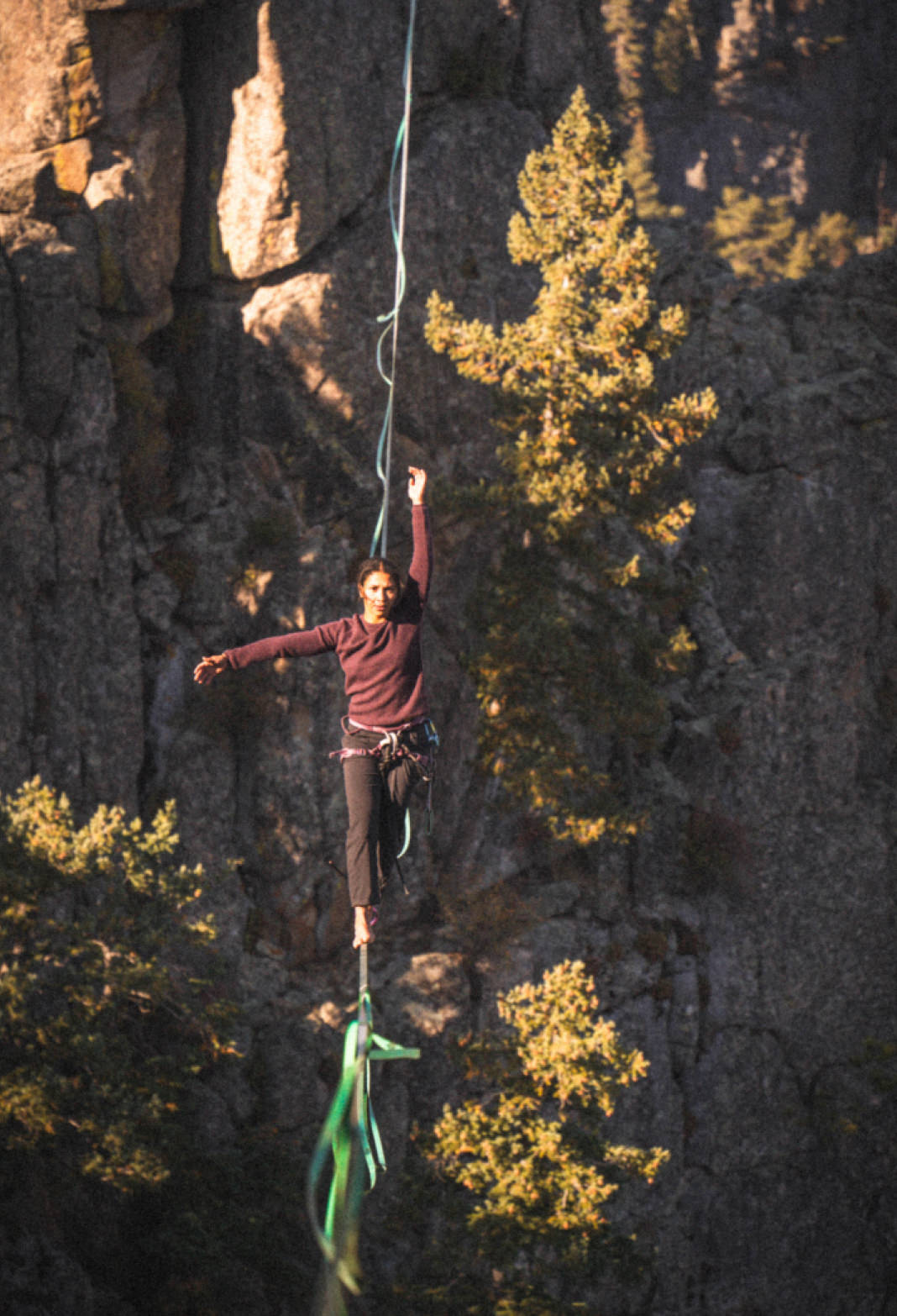 Highliner wearing burgundy Women’s Mountain Crew alpaca sweater, fitted crewneck and durable knit against rocky cliff