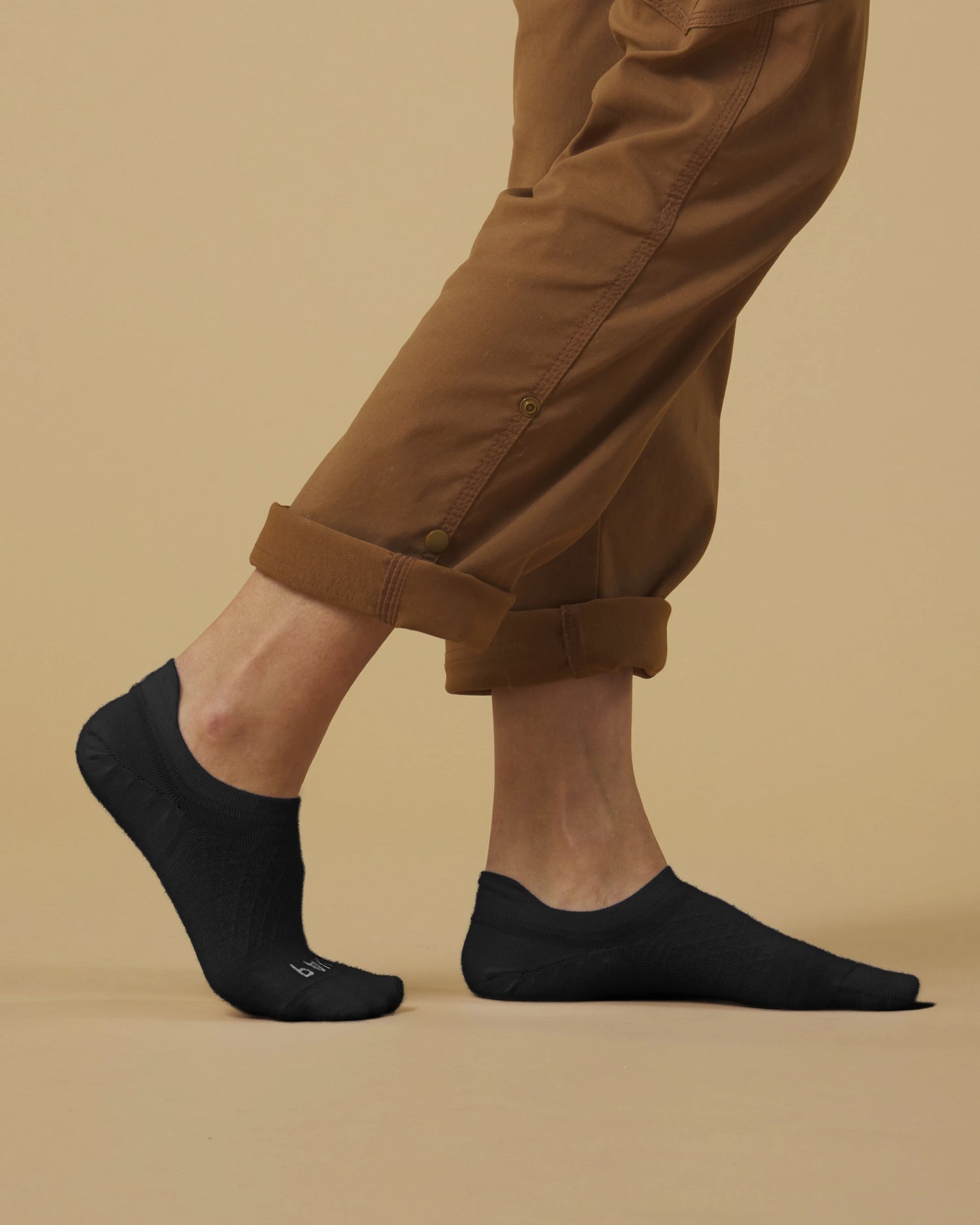 Side view of Timber Essential No Show socks on a model showing low profile, heel stay, and reinforced toe on beige background
