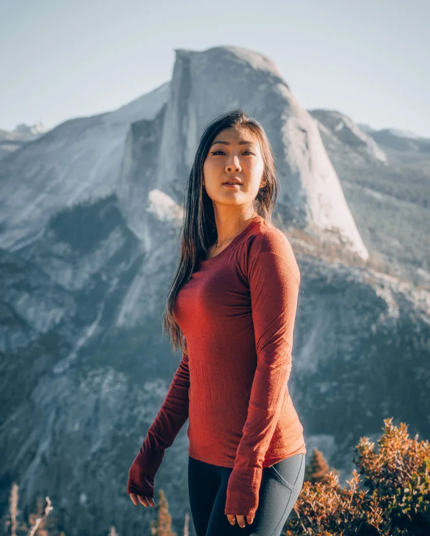 Woman Named Grace in Aire Clay / Red Long Sleeve Hiking Shirt in Front of Half Dome in Yosemite National Park – PAKA Apparel
