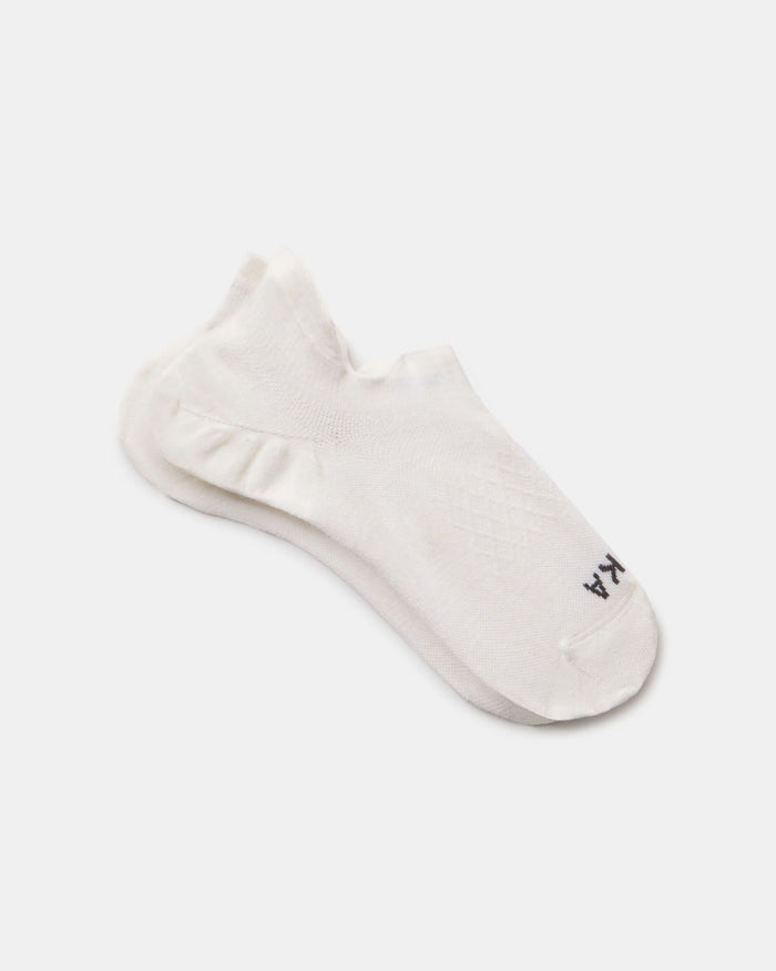 Angled view of white Trail Ankle Socks showing low-cut height, knit pattern, and cushioned sole on light gray background