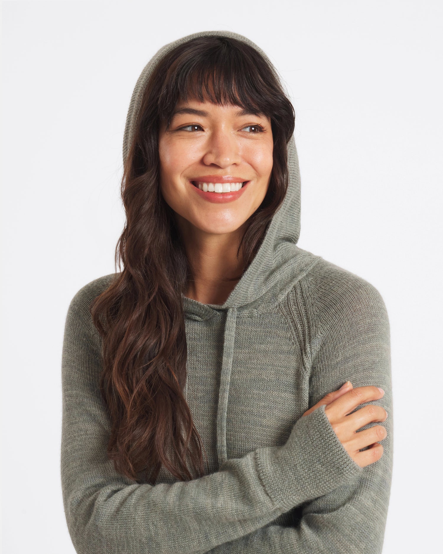Three-quarter view of women’s alpaca hoodie showing hood, raglan sleeves, thumbhole cuffs, lightweight knit in sage green on white