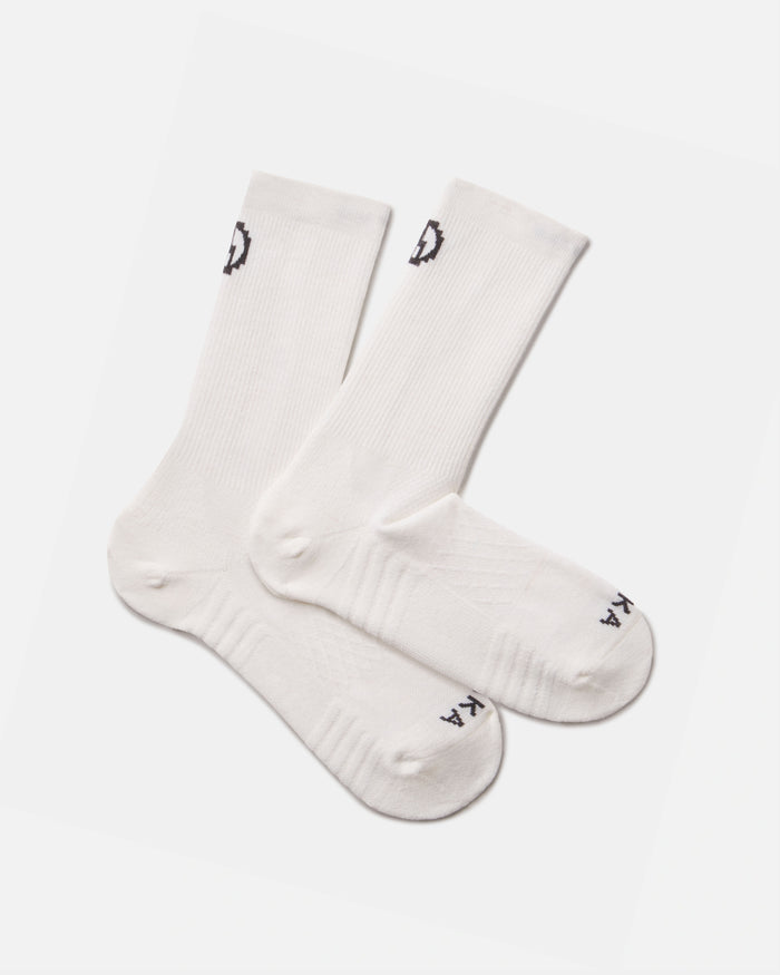Top-down view of white Trail Crew socks showing mid-calf height, ribbed cuff and reinforced heel and toe on a light gray background