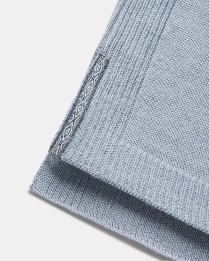 Close-up of women’s alpaca hoodie hem showcasing ribbed knit, side slit, and diamond jacquard trim on a white background