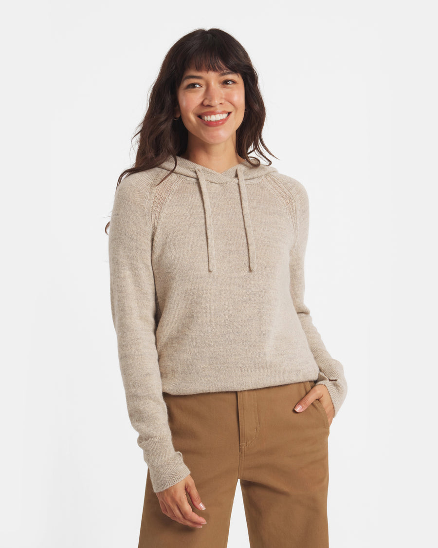 Front view of women’s alpaca hoodie on model showcasing lightweight knit, raglan sleeves, drawstring hood on white background