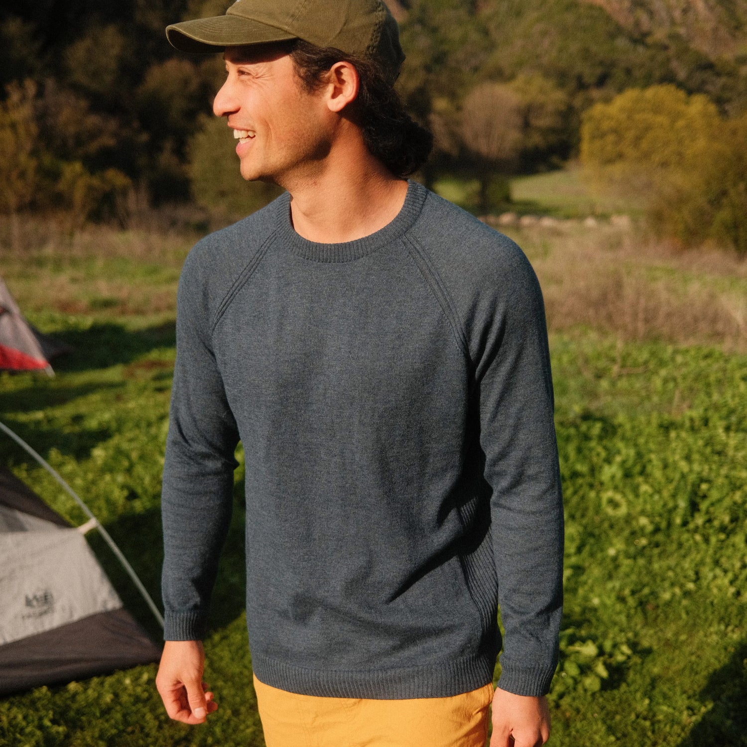 Side view of Men’s Ultralight 1.0 Crew with raglan seams and ribbed crewneck in slate blue, outdoors on a grassy field