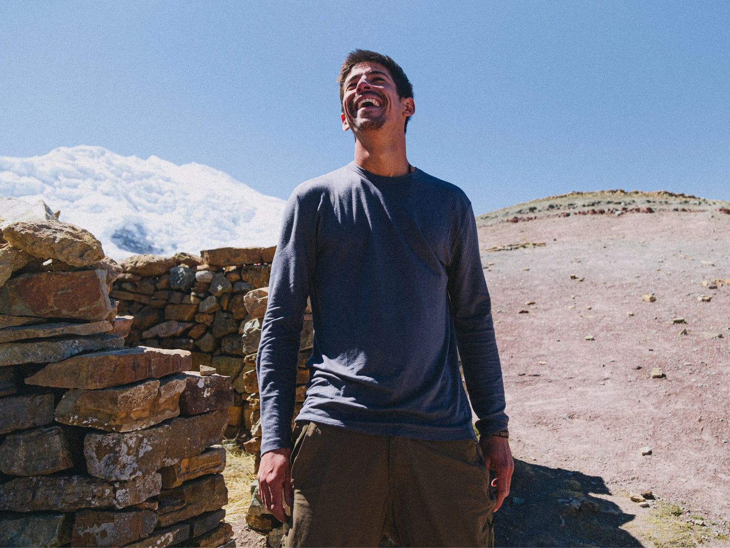 Three-quarter view of Men’s Aire long sleeve alpaca shirt in navy, slim fit on model with rocky mountain background