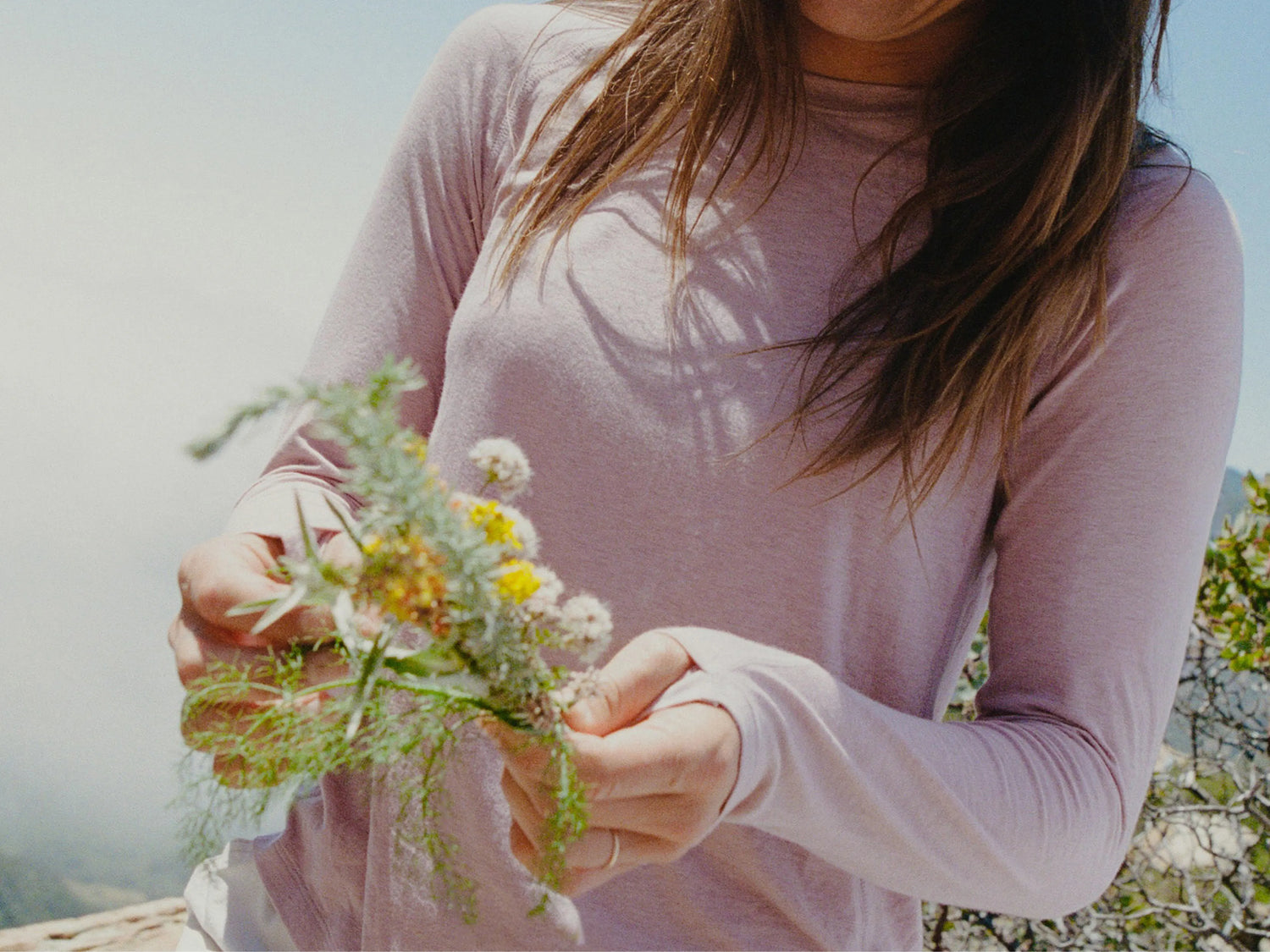 Close-up of Men’s Sol Crew long-sleeve UPF sun shirt in pale mauve showing relaxed fit and extended cuffs on model outdoors