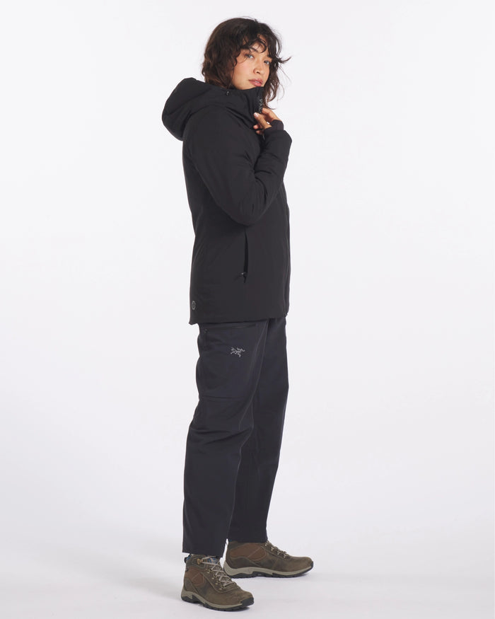 Side view of black Apu Parka with hood and zippered hand pockets, worn in regular fit on white background