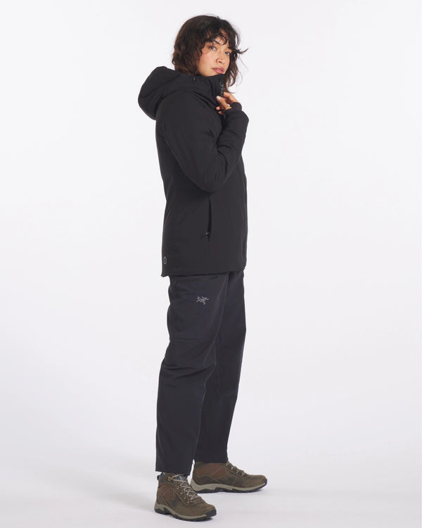 Side view of black Apu Parka with hood and zippered hand pockets, worn in regular fit on white background