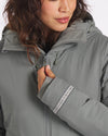 Close-up front view of Apu Parka on a model showing hood, high collar, and zippered chest pocket against a plain white background