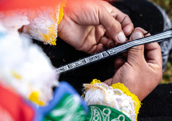 Woman's hands weaving an alpaca bracelet