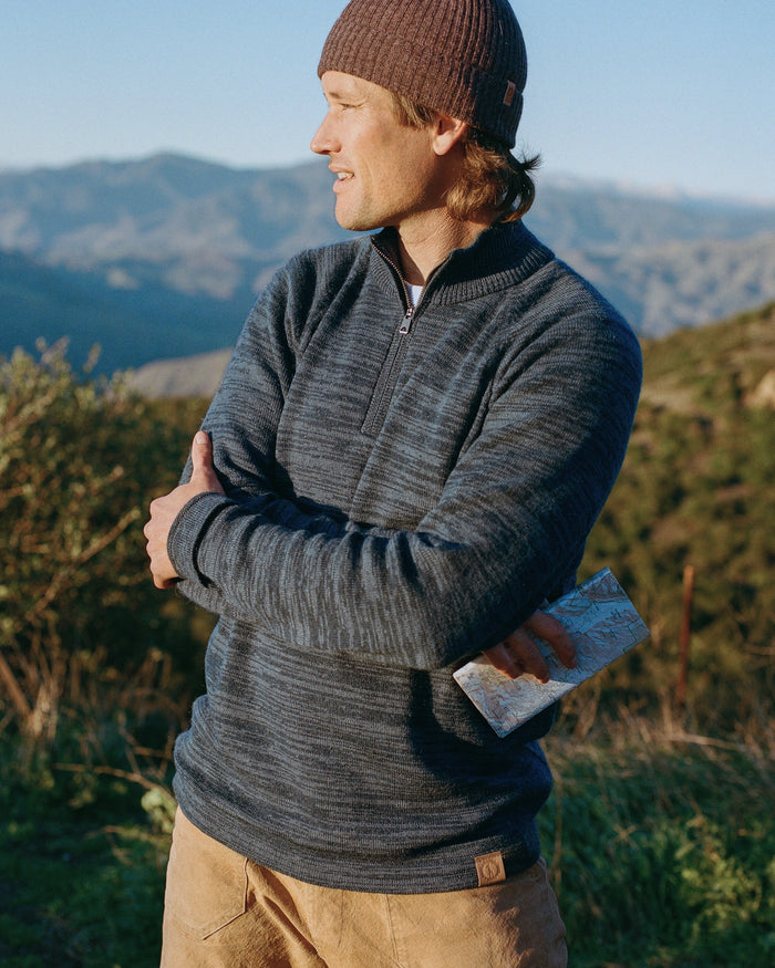 Three-quarter view of Quarter Zip alpaca sweater, marled navy knit, half-zip collar, relaxed fit, mountain hillside background
