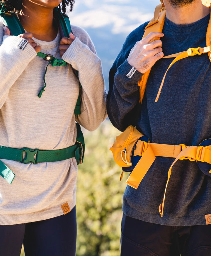 Two backpackers wearing The Hoodie in the nature. The one on the left has alight grey Hoodie, while the one on the right, a charcoal one. 