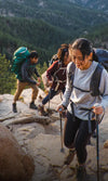 A group of hikers climbing rocks and wearing alpaca garments. 