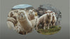 Three alpacas grazing on a grassy hillside with rocky outcrops and a cloudy sky