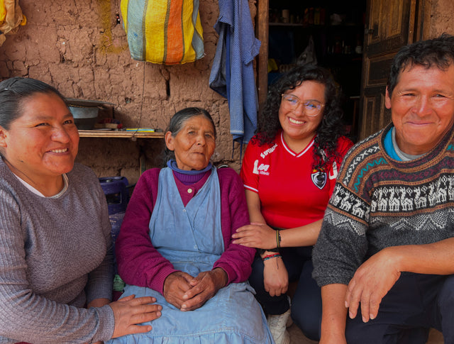 Group of Peruvian young women scholars smiling and sitting together in a home during PAKA scholarship visit
