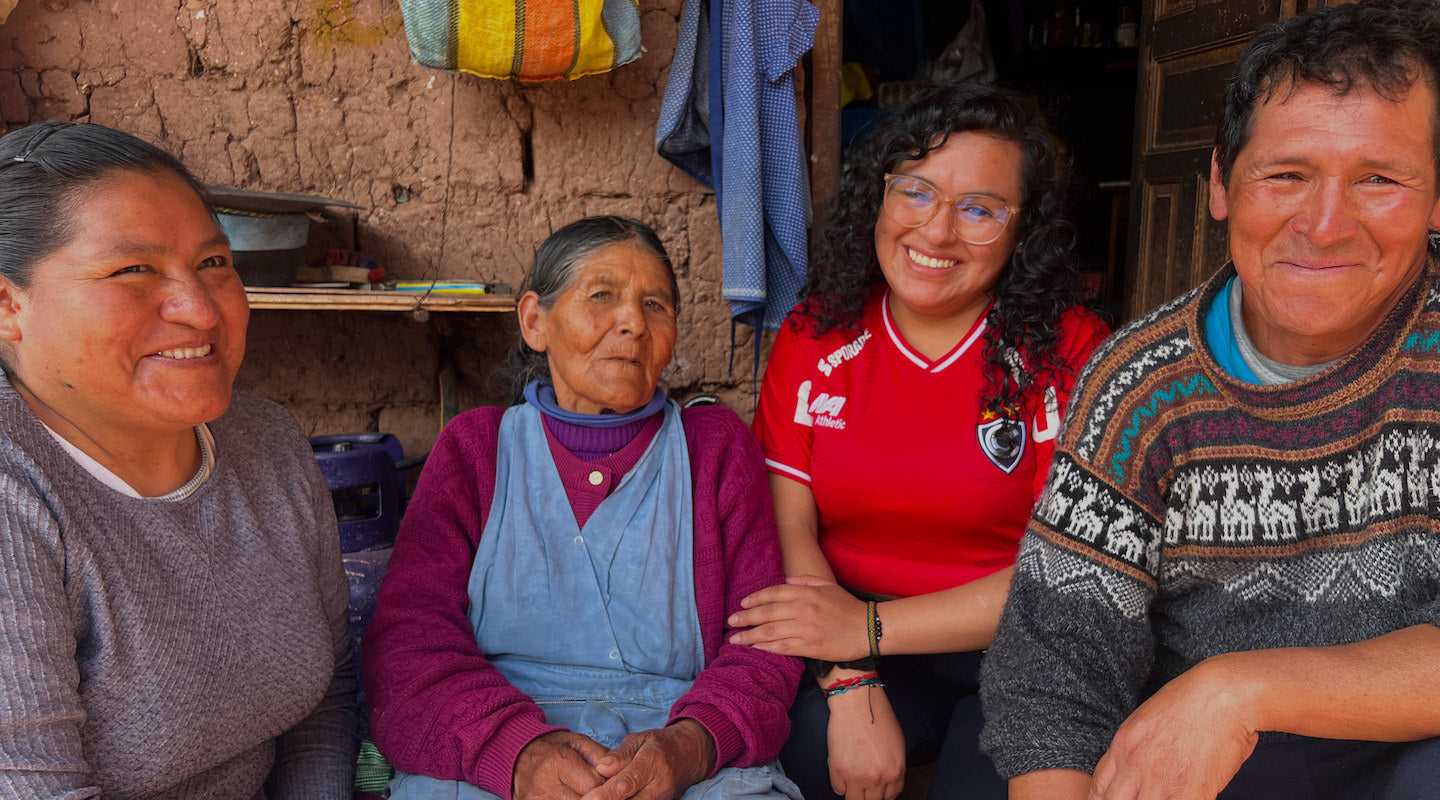PAKA team with Peruvian scholarship recipients smiling together outside in a village setting