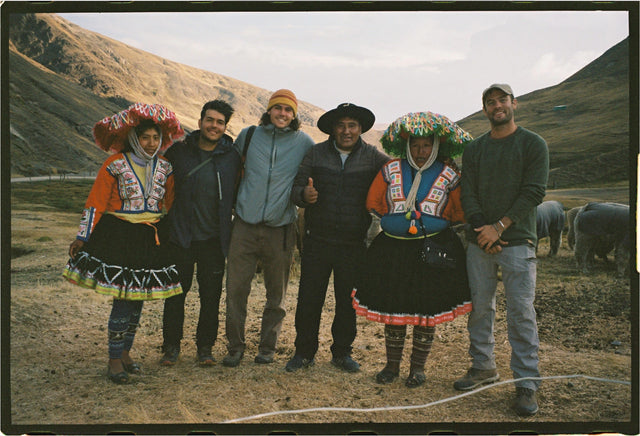 Group of people posing with alpacas in the Andean highlands at sunrise