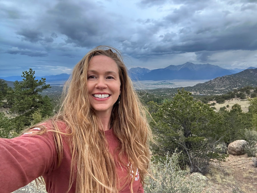 Woman taking a selfie with a scenic mountain landscape in the background