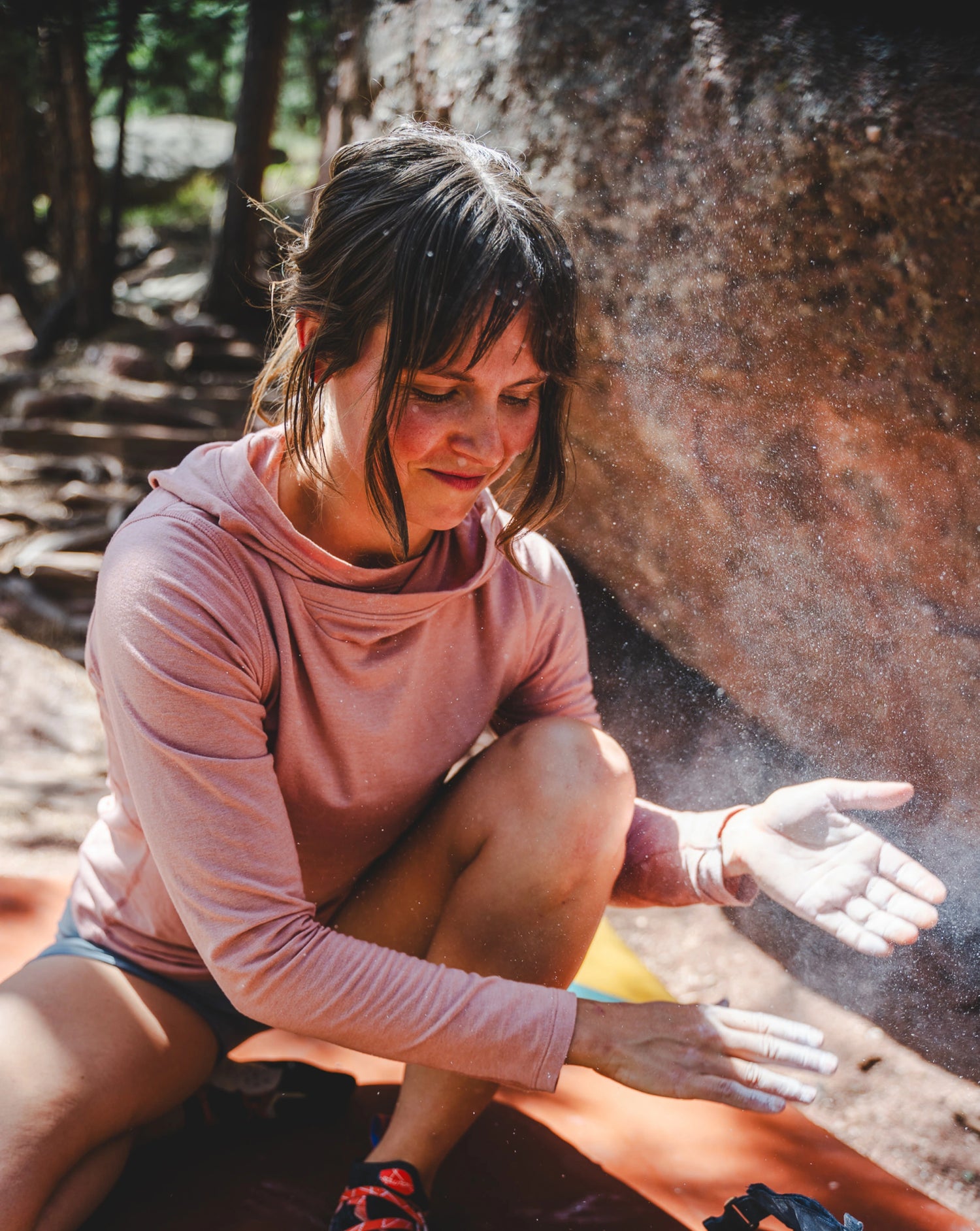 Woman Named Rachael Applying Climber’s Chalk in Sol Sun Hoodie in Guava / Pink – PAKA Apparel