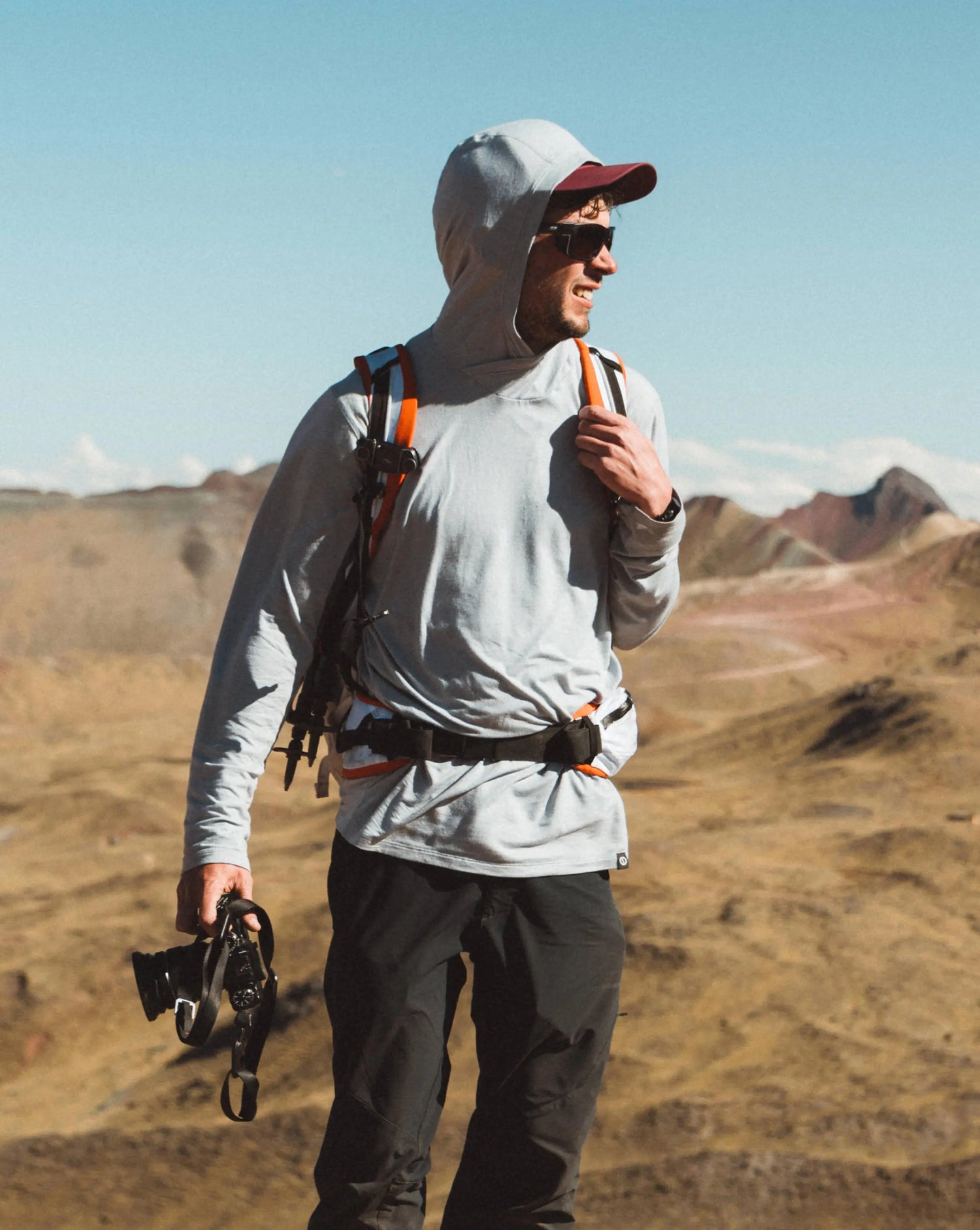 Man Named Louis Wearing Supernova / Grey Sol Men’s Sun Hoodie Outdoors with Camera – PAKA Apparel