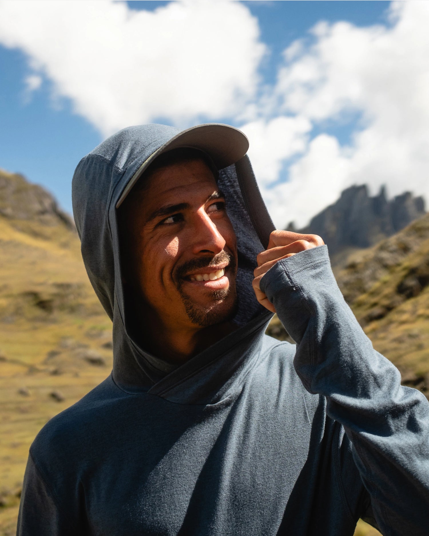 Close Up of Man Named Gabo with Hood Up on Navy Sol Sun Hoodie with Mountains in Background – PAKA Apparel
