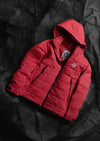 Front flat-lay of red Huascarán puffer jacket showing hood, quilted insulation, zip front and hand pockets on dark background