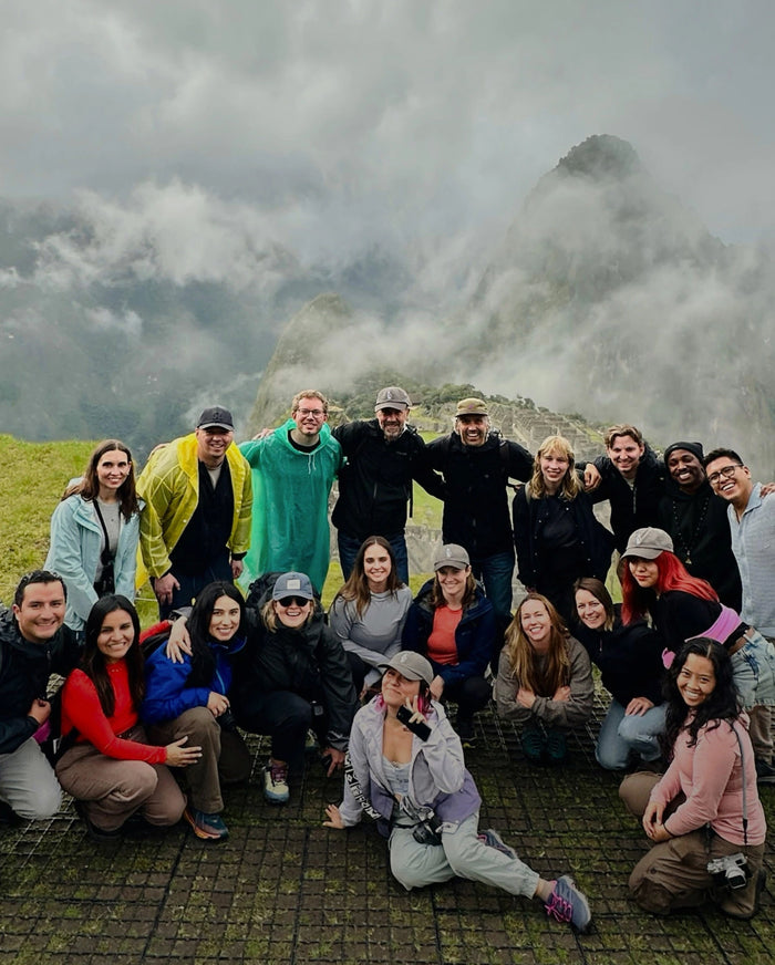 Group of PAKA team members posing on a misty mountain overlook in outdoor alpaca apparel