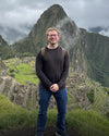 Front view of Men’s Aire Long Sleeve alpaca shirt in charcoal on model showing regular fit with Machu Picchu background