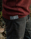 Close-Up of Inca ID on Waist of The Hoodie Sweater in Burgundy Worn by a Person Outdoors – PAKA Apparel