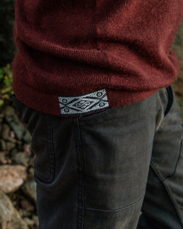 Close-Up of Inca ID on Waist of The Hoodie Sweater in Burgundy Worn by a Person Outdoors – PAKA Apparel
