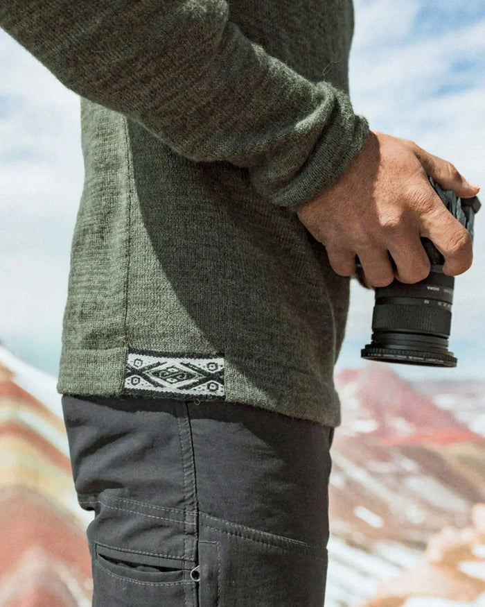Side close-up of The Original Crew alpaca crewneck in eucalyptus showing knit texture and woven hem tag on a model
