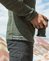Side close-up of The Original Crew alpaca crewneck in eucalyptus showing knit texture and woven hem tag on a model