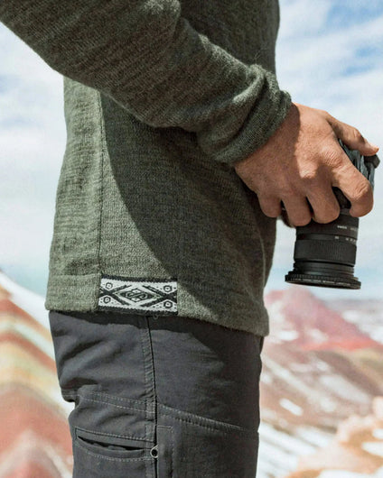Side close-up of The Original Crew alpaca crewneck in eucalyptus showing knit texture and woven hem tag on a model
