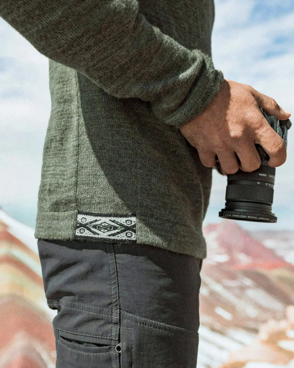 Side close-up of The Original Crew alpaca crewneck in eucalyptus showing knit texture and woven hem tag on a model